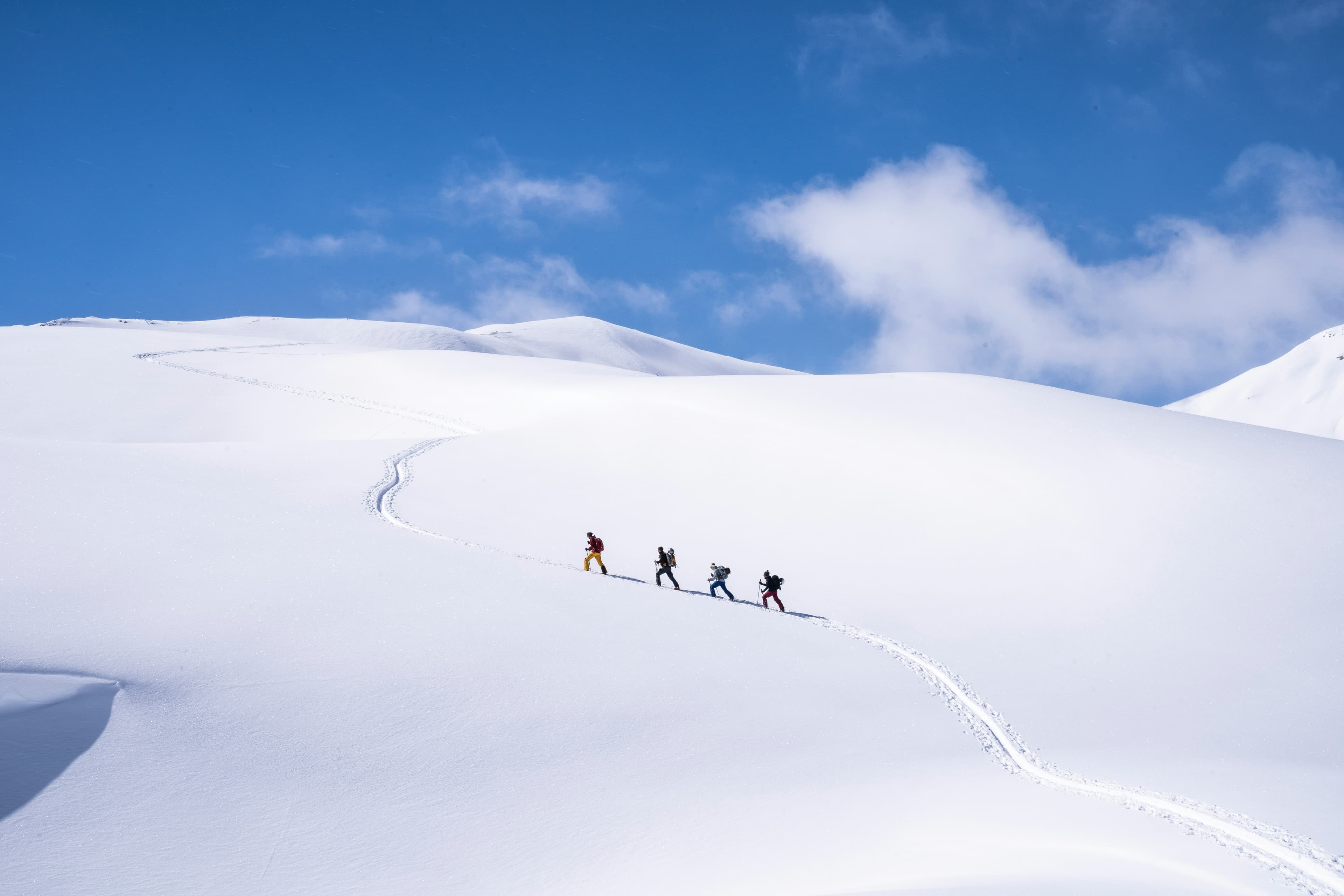 Backcountry group skinning through snow-covered mountains